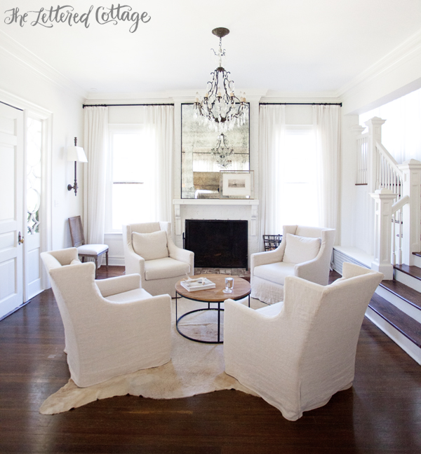 Neutral Living Room | White | Slipcovers | Cowhide Rug | Wall Sconces | Fireplace | Round Coffee Table | Ashley Gilbreath Interiors